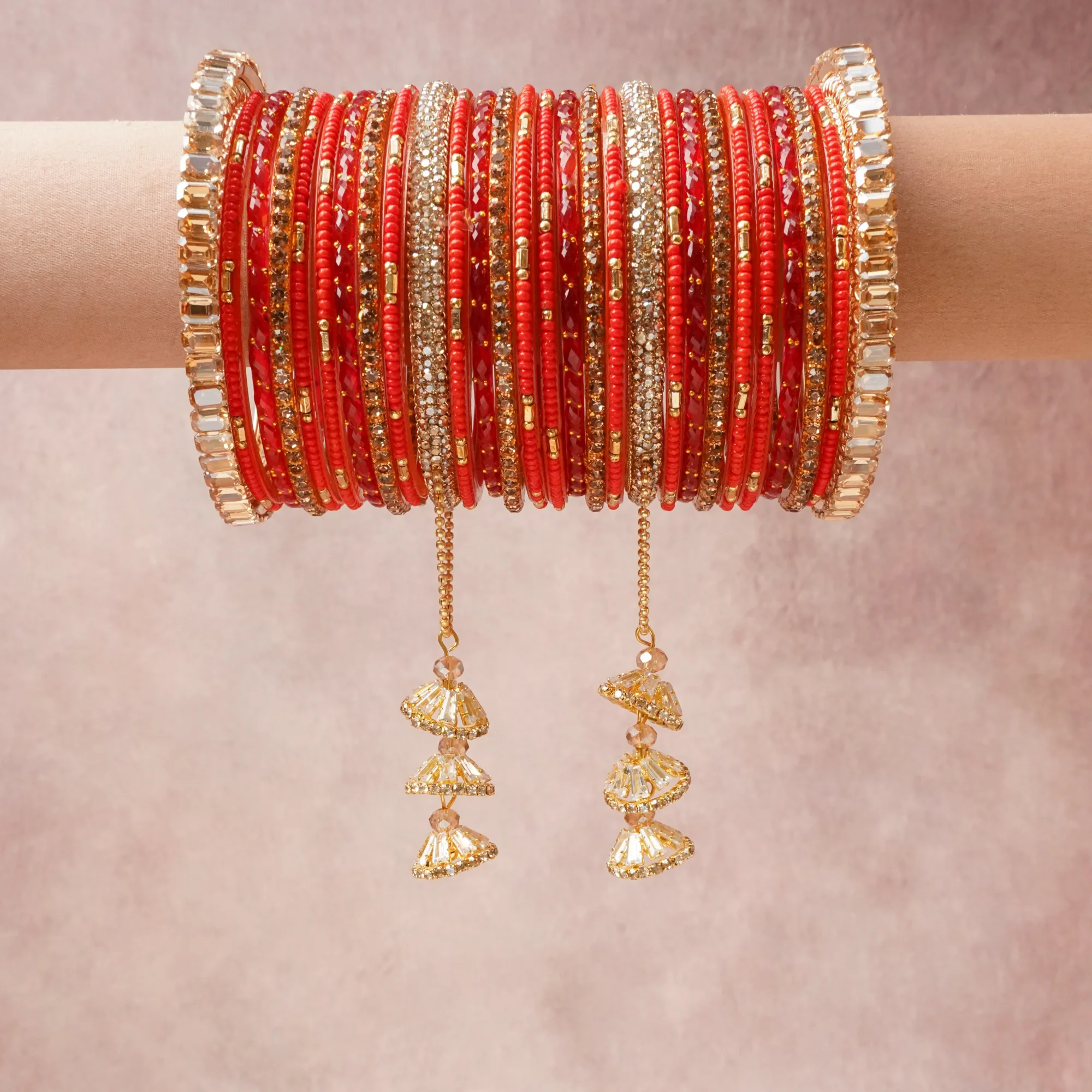 A grounding Scarlet Red forms the heart of the set, while touches of Bright Gold, Clear Faceted Crystal, Champagne Faceted Crystal add charm.

A thoughtful composition of Glass (bangles and seed beads), Gold-plated Metal (bangle frames, chains, and smaller bead elements), Faceted Glass Crystals (embellishments and dangling components), designed to feel complete without being heavy.
Each element layers seamlessly, creating a look that is refined, wearable and quietly striking.